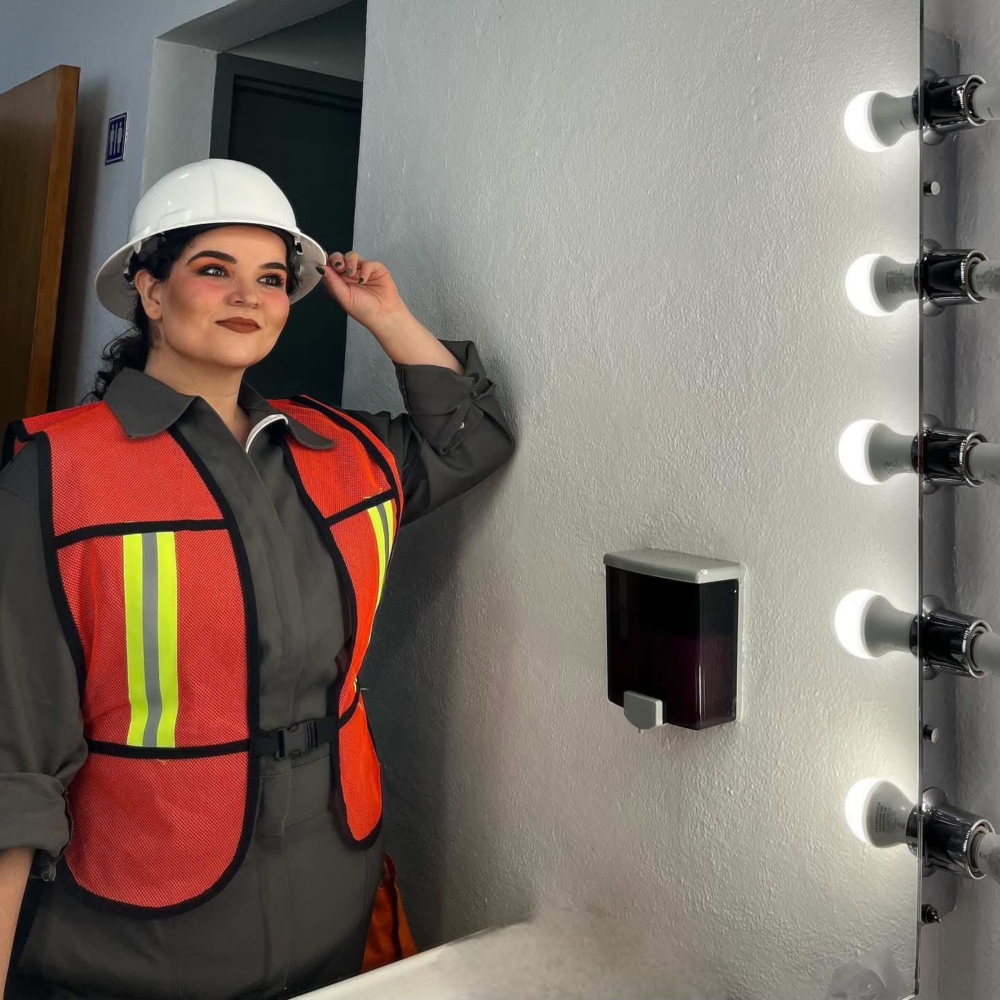 Stefany caracterizada en el camerino con casco y chaleco de la producción