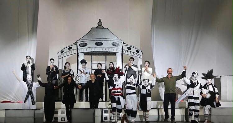 Elenco completo saludando al público en blanco y negro