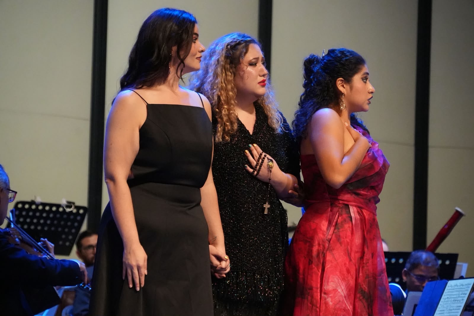 Stefany Cruz-Chousal de perfil junto a dos cantantes en una escena de ópera